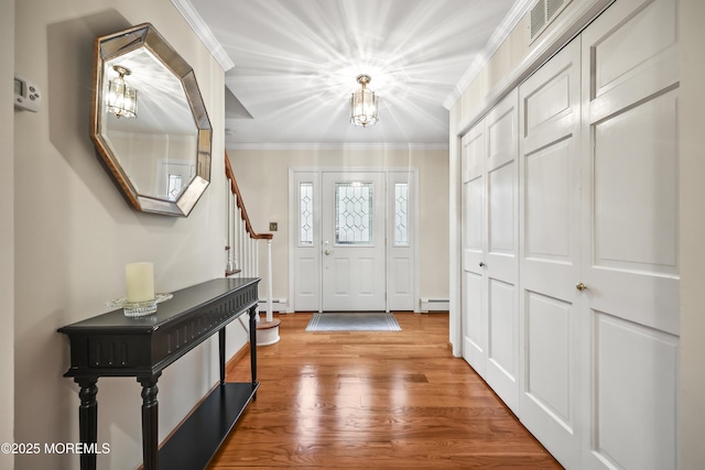 6 Stoecker Rd, Holmdel, NJ 07733 - entrance foyer featuring baseboard heating, ornamental molding, wood finished floors, and stairway