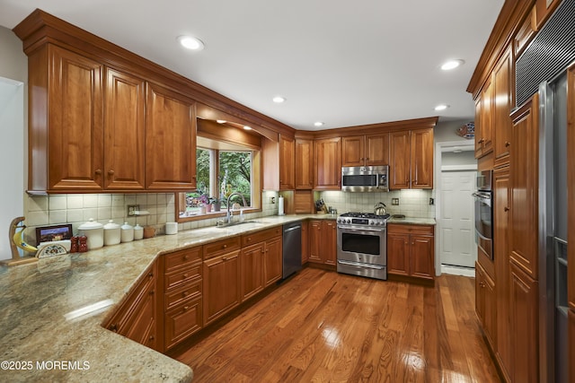 6 Stoecker Rd, Holmdel, NJ 07733 - kitchen with appliances with stainless steel finishes, light stone countertops, dark wood-style floors, tasteful backsplash, and brown cabinetry