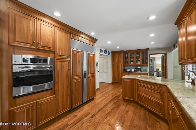 6 Stoecker Rd, Holmdel, NJ 07733 - kitchen with paneled fridge, stainless steel oven, brown cabinets, wood finished floors, and recessed lighting
