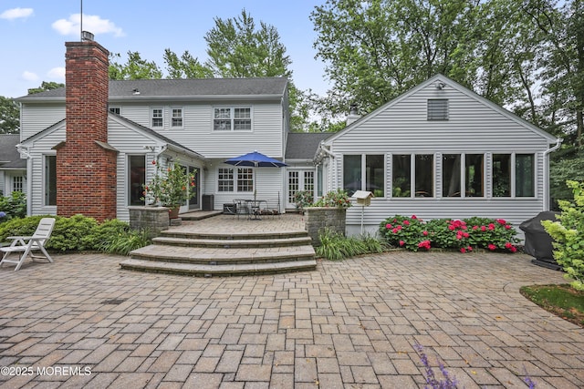 6 Stoecker Rd, Holmdel, NJ 07733 - rear view of house featuring a wooden deck, a chimney, and a patio area