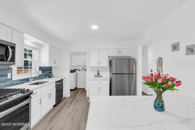 455 Drum Point Rd, Brick, NJ 08723 - kitchen featuring stainless steel appliances, white cabinetry, light stone countertops, backsplash, and light wood finished floors