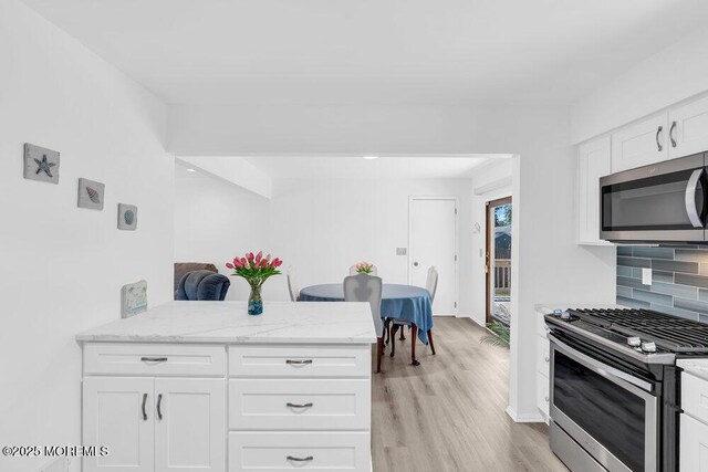 455 Drum Point Rd, Brick, NJ 08723 - kitchen featuring appliances with stainless steel finishes, light wood-style floors, backsplash, and white cabinets