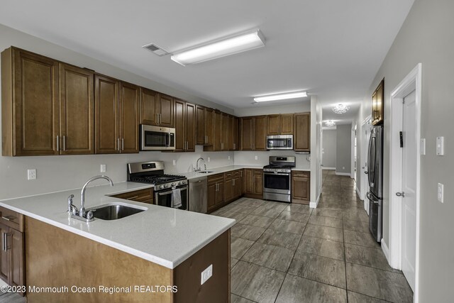 7 Regal Ct, Lakewood, NJ 08701 - kitchen featuring appliances with stainless steel finishes, light countertops, and a peninsula