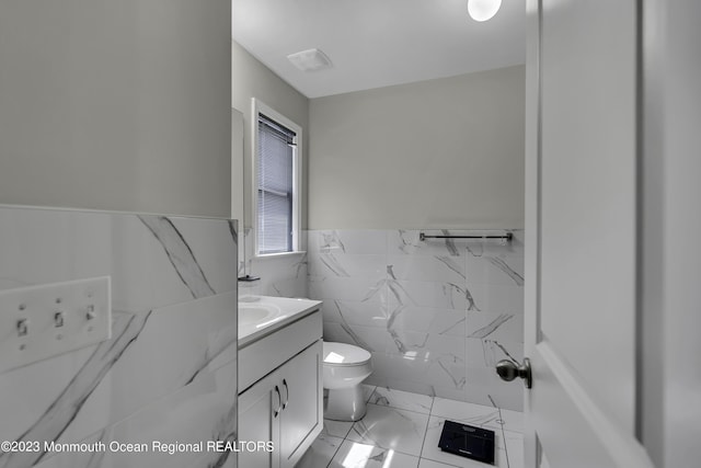 7 Regal Ct, Lakewood, NJ 08701 - bathroom with marble look tiles, a wainscoted wall, vanity, and tile walls