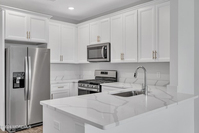 750 Lighthouse Dr Unit 1112, Barnegat, NJ 08005 - kitchen with appliances with stainless steel finishes, a peninsula, light stone counters, white cabinets, and recessed lighting