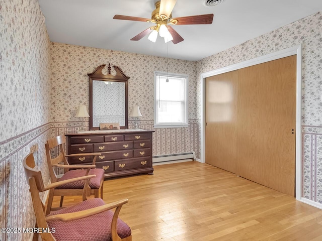 136 Georgetown Rd, Toms River, NJ 08757 - sitting room with wallpapered walls, a baseboard heating unit, a ceiling fan, and light wood-type flooring