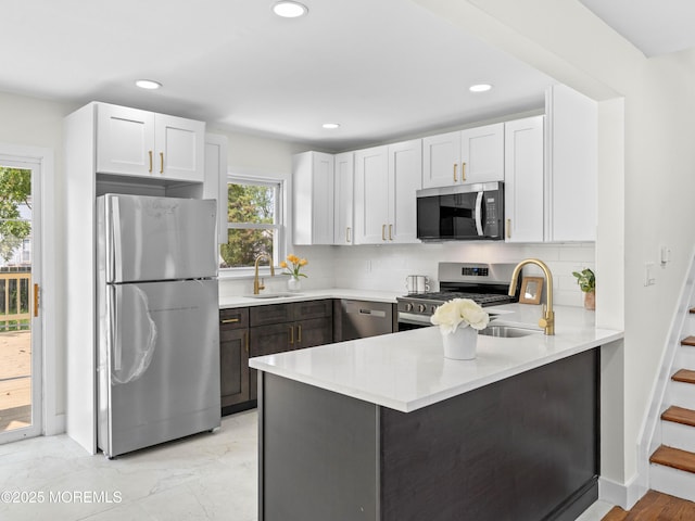 37 Bryant Dr, Jackson, NJ 08527 - kitchen featuring stainless steel appliances, a peninsula, backsplash, light countertops, and white cabinetry