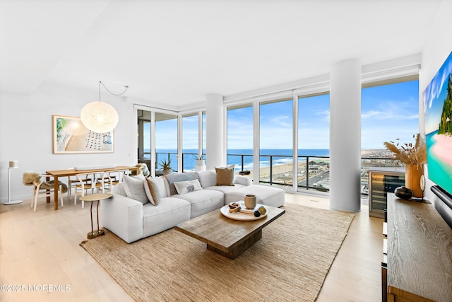 1101 Ocean Ave Unit 1404, Asbury Park, NJ 07712 - living room featuring a water view, wood finished floors, a wall of windows, and beverage cooler
