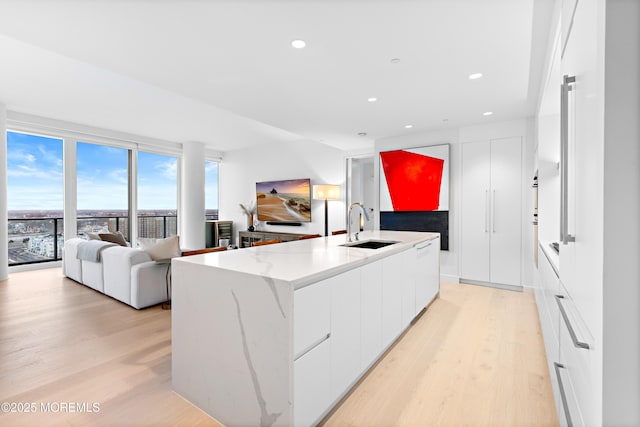 1101 Ocean Ave Unit 1404, Asbury Park, NJ 07712 - kitchen with modern cabinets, light wood-style floors, white cabinetry, a kitchen island with sink, and open floor plan