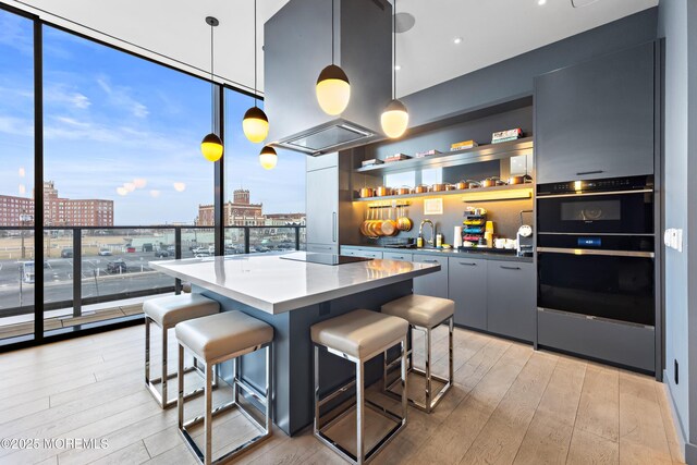 1101 Ocean Ave Unit 1404, Asbury Park, NJ 07712 - kitchen with a breakfast bar area, a center island, light wood-type flooring, plenty of natural light, and expansive windows