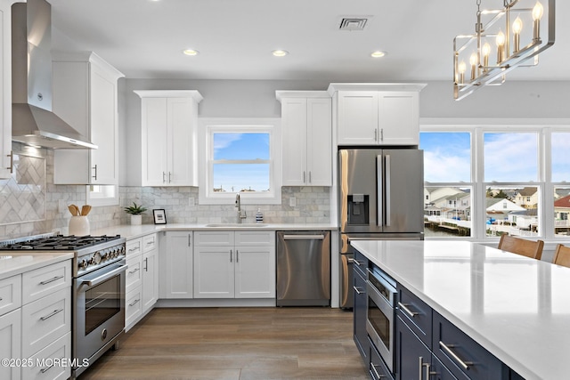 56 Gregg Dr, Beach Haven West, NJ 08050 - kitchen featuring wall chimney range hood, appliances with stainless steel finishes, white cabinetry, light countertops, and recessed lighting