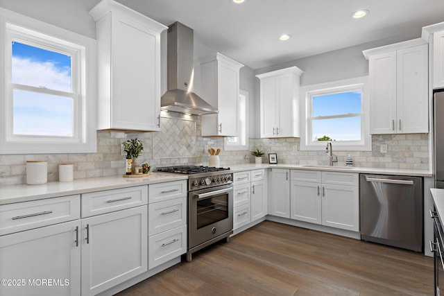 56 Gregg Dr, Beach Haven West, NJ 08050 - kitchen with appliances with stainless steel finishes, wall chimney range hood, white cabinetry, tasteful backsplash, and light countertops