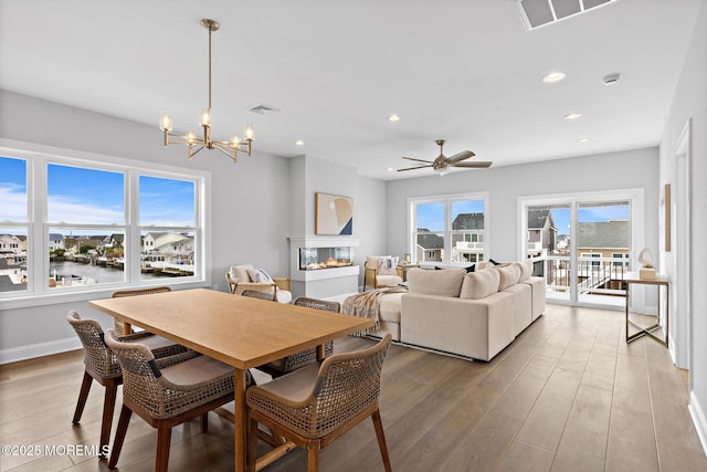 56 Gregg Dr, Beach Haven West, NJ 08050 - dining room with light wood-style floors, a chandelier, recessed lighting, a ceiling fan, and a multi sided fireplace
