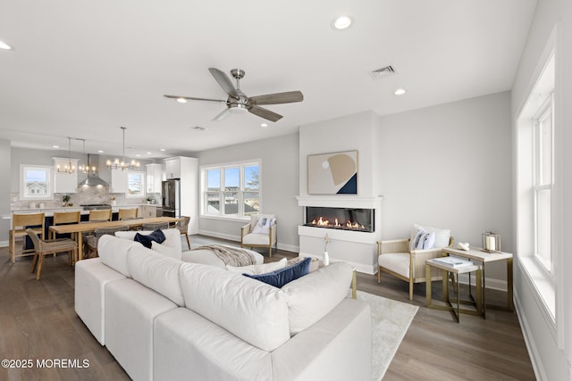 56 Gregg Dr, Beach Haven West, NJ 08050 - living room featuring recessed lighting, a glass covered fireplace, a chandelier, wood finished floors, and a ceiling fan