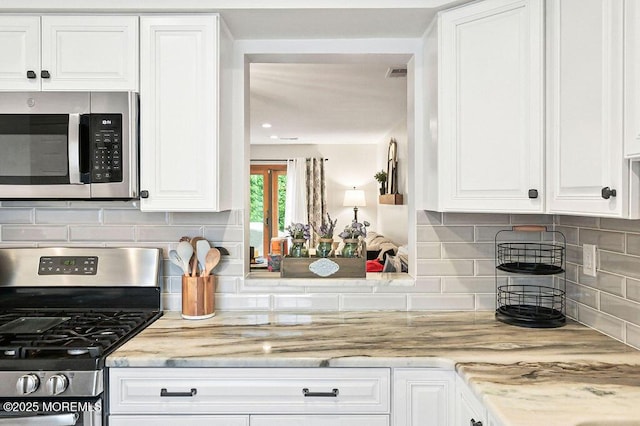 49 Scarborough Ct Unit 3, Freehold, NJ 07728 - kitchen with stainless steel appliances, white cabinets, backsplash, and light stone counters
