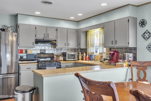 8 Tijuana Ct, Toms River, NJ 08757 - kitchen featuring stainless steel appliances, under cabinet range hood, a peninsula, light countertops, and decorative backsplash