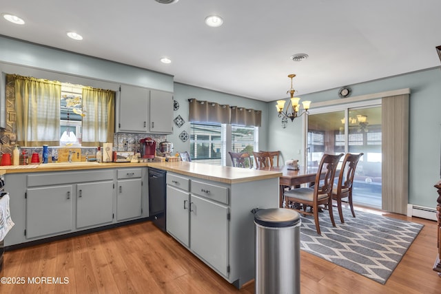 8 Tijuana Ct, Toms River, NJ 08757 - kitchen featuring dishwasher, a peninsula, a chandelier, light wood-style floors, and baseboard heating