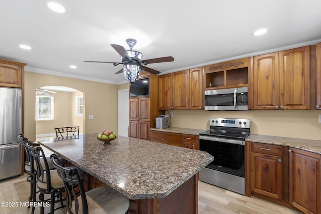 1792 Todd Rd, Toms River, NJ 08755 - kitchen featuring stainless steel appliances, a ceiling fan, a kitchen breakfast bar, light wood-style floors, and dark stone countertops