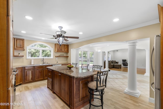 1792 Todd Rd, Toms River, NJ 08755 - kitchen featuring decorative columns, stainless steel appliances, arched walkways, a breakfast bar area, and a center island