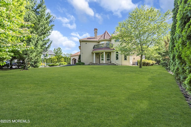 5 Champlain Ct, Lakewood, NJ 08701 - rear view of house with a balcony, stucco siding, a lawn, and a chimney