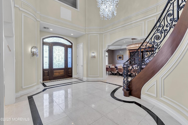 5 Champlain Ct, Lakewood, NJ 08701 - entryway featuring inlaid floor details, arched walkways, stairway, a decorative wall, and a chandelier