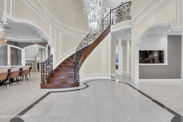 5 Champlain Ct, Lakewood, NJ 08701 - foyer entrance featuring inlaid floor details, arched walkways, a towering ceiling, stairway, and crown molding