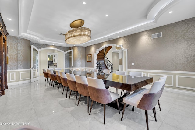 5 Champlain Ct, Lakewood, NJ 08701 - dining room featuring arched walkways, a raised ceiling, a decorative wall, recessed lighting, and wainscoting