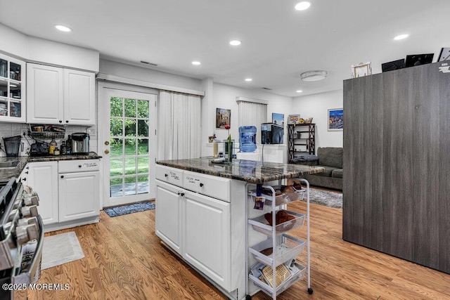 58 Hedge Dr, Lakewood, NJ 08701 - kitchen featuring a kitchen bar, stainless steel stove, light wood-style flooring, glass insert cabinets, and white cabinets