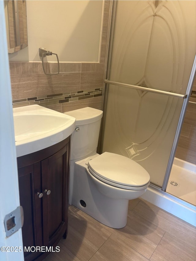 101 Bonaire Dr, Toms River, NJ 08757 - bathroom with vanity, a stall shower, tile walls, and a wainscoted wall
