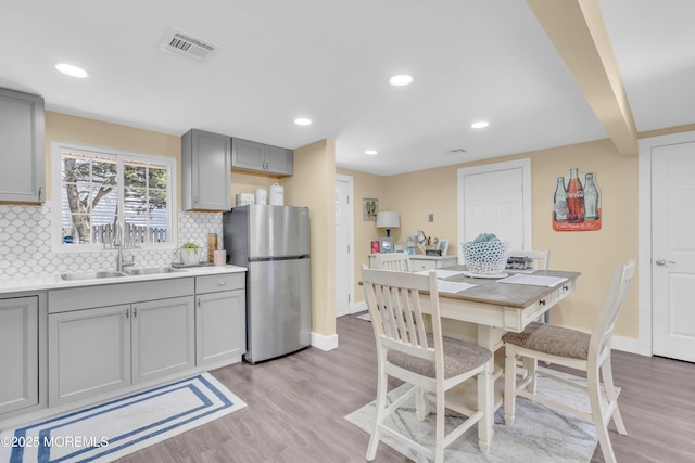 200 Ceylon Ave, Seaside Heights, NJ 08751 - kitchen with freestanding refrigerator, gray cabinetry, light wood-style flooring, backsplash, and light countertops