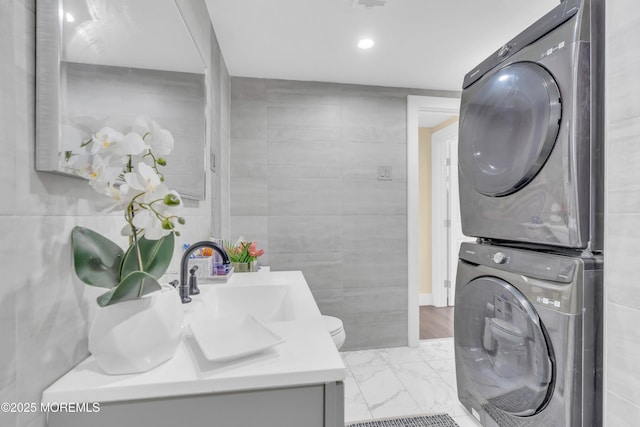 200 Ceylon Ave, Seaside Heights, NJ 08751 - laundry area featuring stacked washing machine and dryer, tile walls, light marble finish flooring, and recessed lighting