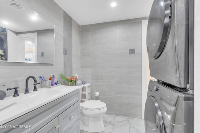 200 Ceylon Ave, Seaside Heights, NJ 08751 - bathroom featuring stacked washing machine and dryer, marble look tile flooring, tile walls, vanity, and recessed lighting