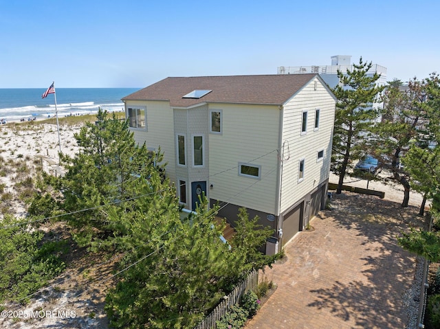 208 E 20th St, Long Beach Twp, NJ 08008 - view of property exterior with decorative driveway, view of water and beach, and a garage