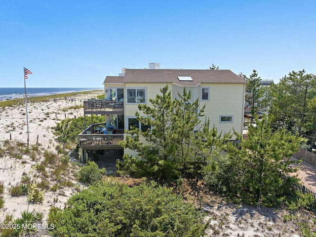 208 E 20th St, Long Beach Twp, NJ 08008 - rear view of property featuring a deck with water view and a beach view