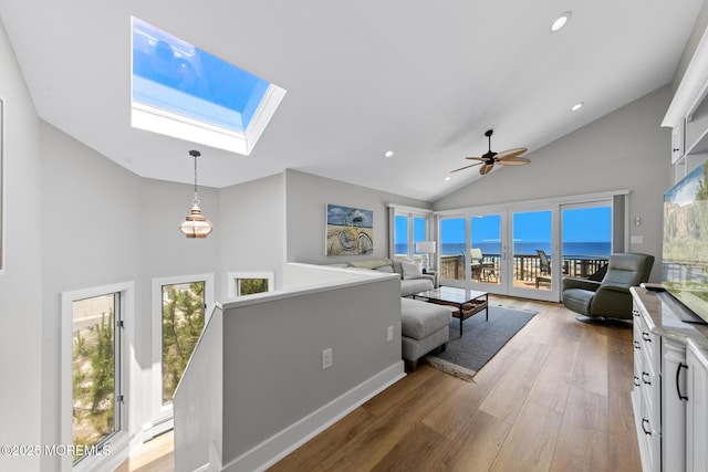 208 E 20th St, Long Beach Twp, NJ 08008 - living area featuring high vaulted ceiling, a skylight, baseboard heating, wood finished floors, and healthy amount of natural light