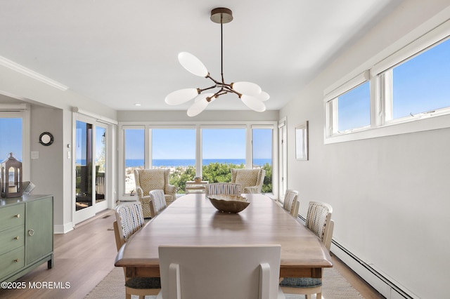 208 E 20th St, Long Beach Twp, NJ 08008 - dining area featuring baseboard heating, a chandelier, wood finished floors, and a water view