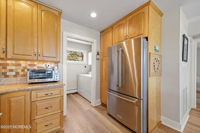 208 E 20th St, Long Beach Twp, NJ 08008 - kitchen featuring high end fridge, washer and clothes dryer, light wood finished floors, light stone countertops, and tasteful backsplash