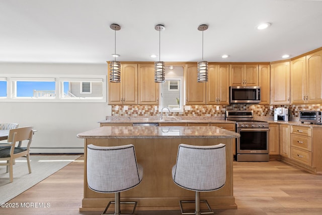 208 E 20th St, Long Beach Twp, NJ 08008 - kitchen featuring stainless steel appliances, light wood-style flooring, a kitchen breakfast bar, a center island, and recessed lighting