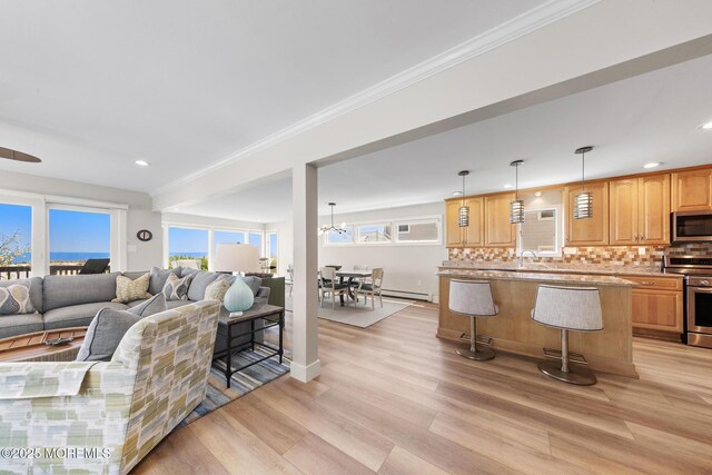 208 E 20th St, Long Beach Twp, NJ 08008 - living area featuring light wood-style flooring, healthy amount of natural light, baseboard heating, recessed lighting, and crown molding