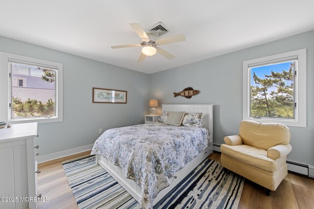 208 E 20th St, Long Beach Twp, NJ 08008 - bedroom featuring light wood-style flooring, baseboard heating, and a ceiling fan