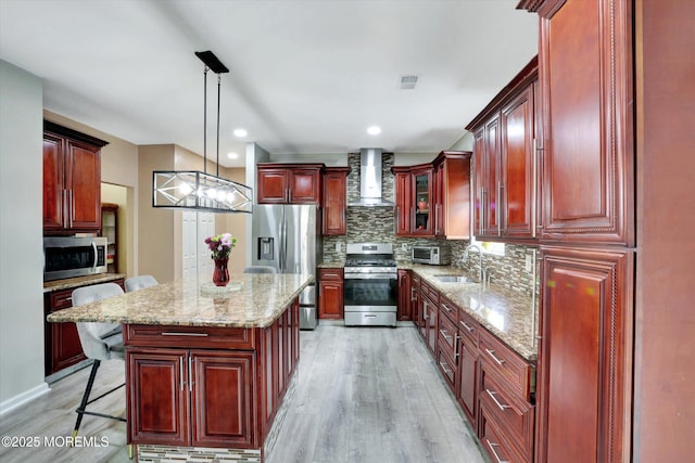 1041 Aumack Rd, Jackson, NJ 08527 - kitchen with stainless steel appliances, reddish brown cabinets, wall chimney exhaust hood, light wood-style flooring, and backsplash