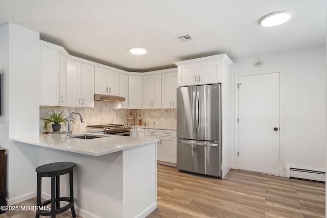 9 Maniwaki Ct, Toms River, NJ 08757 - kitchen with appliances with stainless steel finishes, baseboard heating, white cabinets, light countertops, and a peninsula
