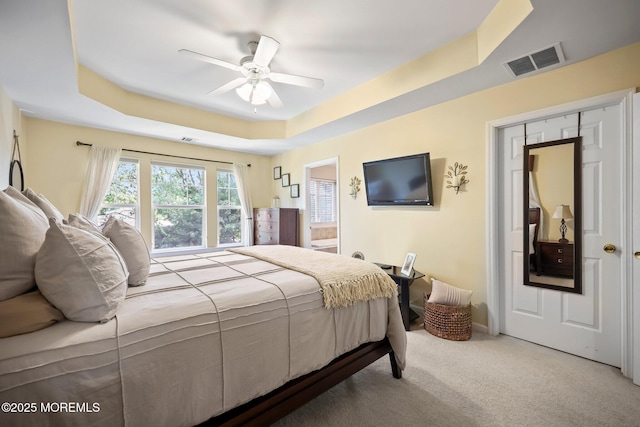 100 Pine St Unit 9, Lakehurst, NJ 08733 - carpeted bedroom featuring a raised ceiling, connected bathroom, and ceiling fan