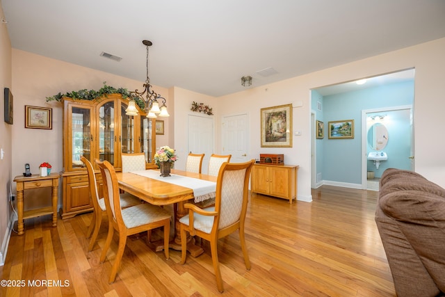 203 Canterbury Ln, Morganville, NJ 07751 - dining area featuring light wood-style flooring and a chandelier