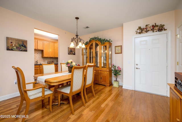 203 Canterbury Ln, Morganville, NJ 07751 - dining room with light wood-style floors and a chandelier