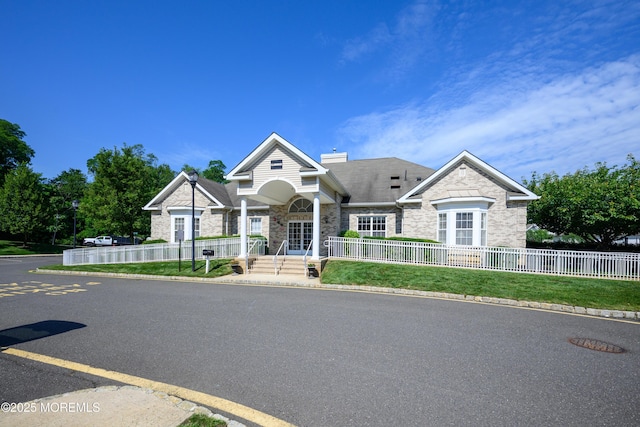 203 Canterbury Ln, Morganville, NJ 07751 - craftsman-style house with stone siding, a fenced front yard, and a chimney