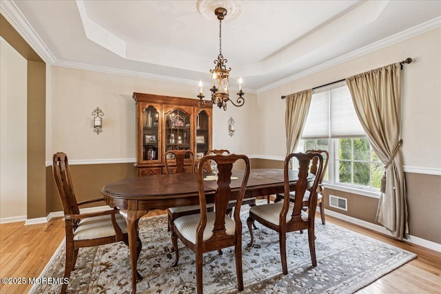 140 Palisade Dr, Freehold, NJ 07728 - dining room featuring a chandelier, a tray ceiling, light wood-style flooring, and ornamental molding