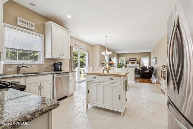 140 Palisade Dr, Freehold, NJ 07728 - kitchen with appliances with stainless steel finishes, open floor plan, backsplash, a chandelier, and white cabinetry
