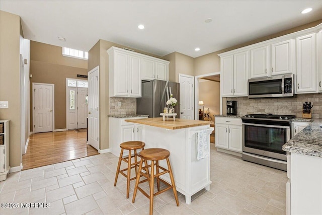 140 Palisade Dr, Freehold, NJ 07728 - kitchen featuring stainless steel appliances, backsplash, white cabinets, a center island, and recessed lighting