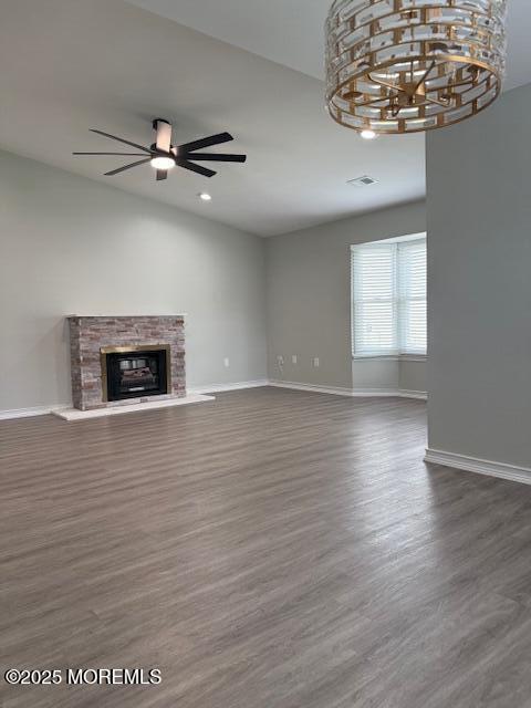 11 Ivy Rdg Unit 1000, Howell, NJ 07728 - unfurnished living room featuring a ceiling fan, dark wood-style floors, a fireplace with raised hearth, recessed lighting, and a chandelier